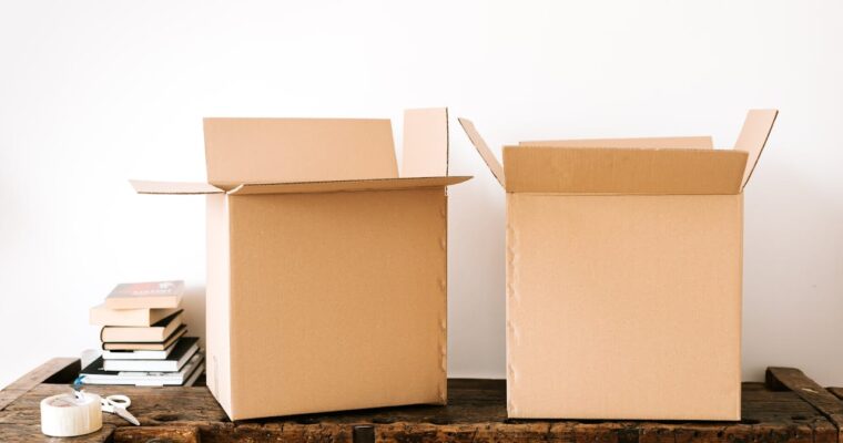 Cardboard boxes and stacked books on a wooden surface