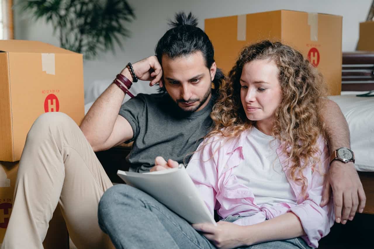 Man watching his partner writing in a notebook while moving house