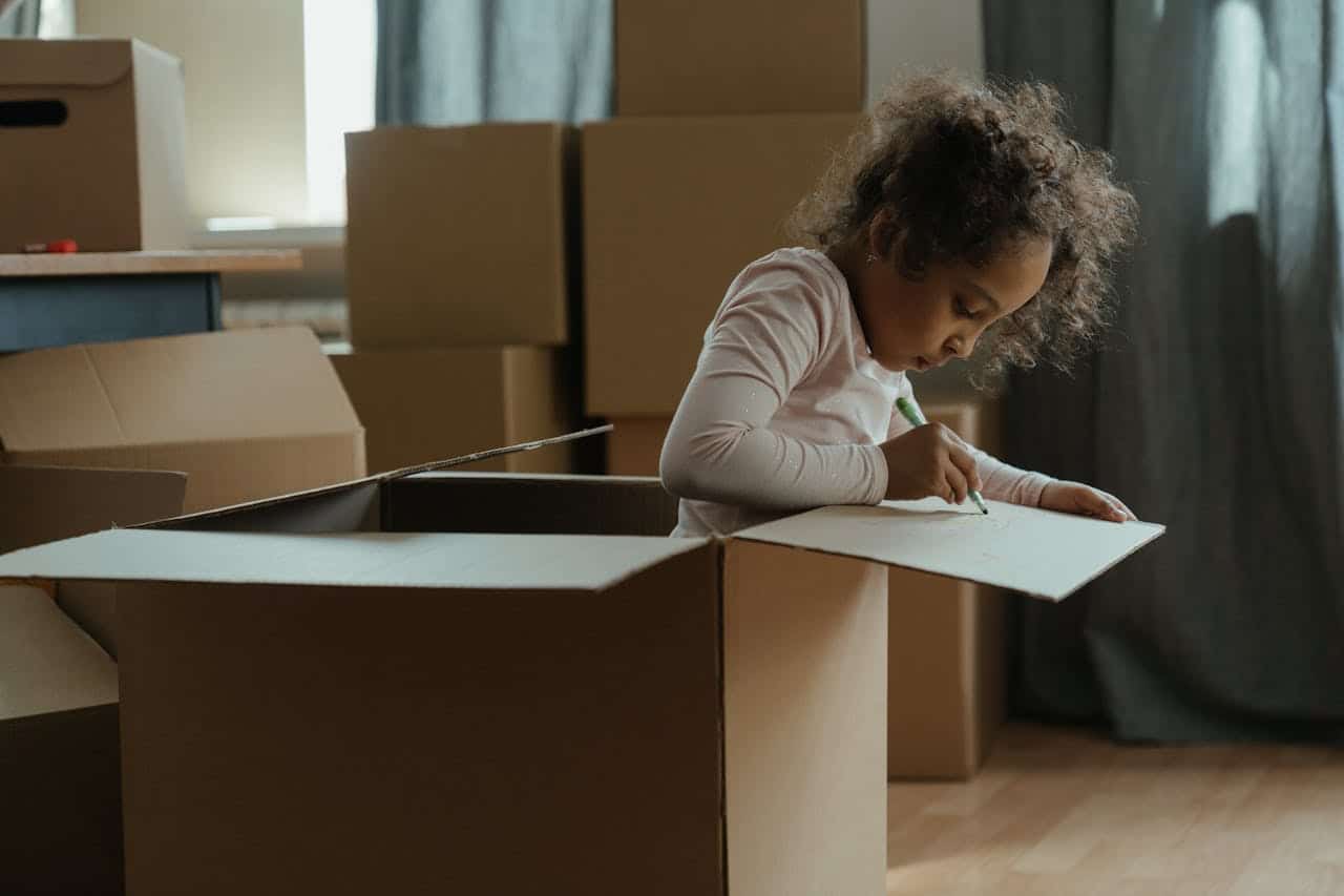 Girl writing on a cardboard box